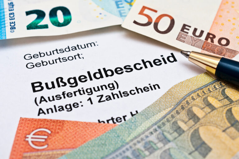 Close-up of a German form with personal fields (e.g., Geburtsdatum) and a pen, with euro banknotes around it, suggesting financial paperwork.